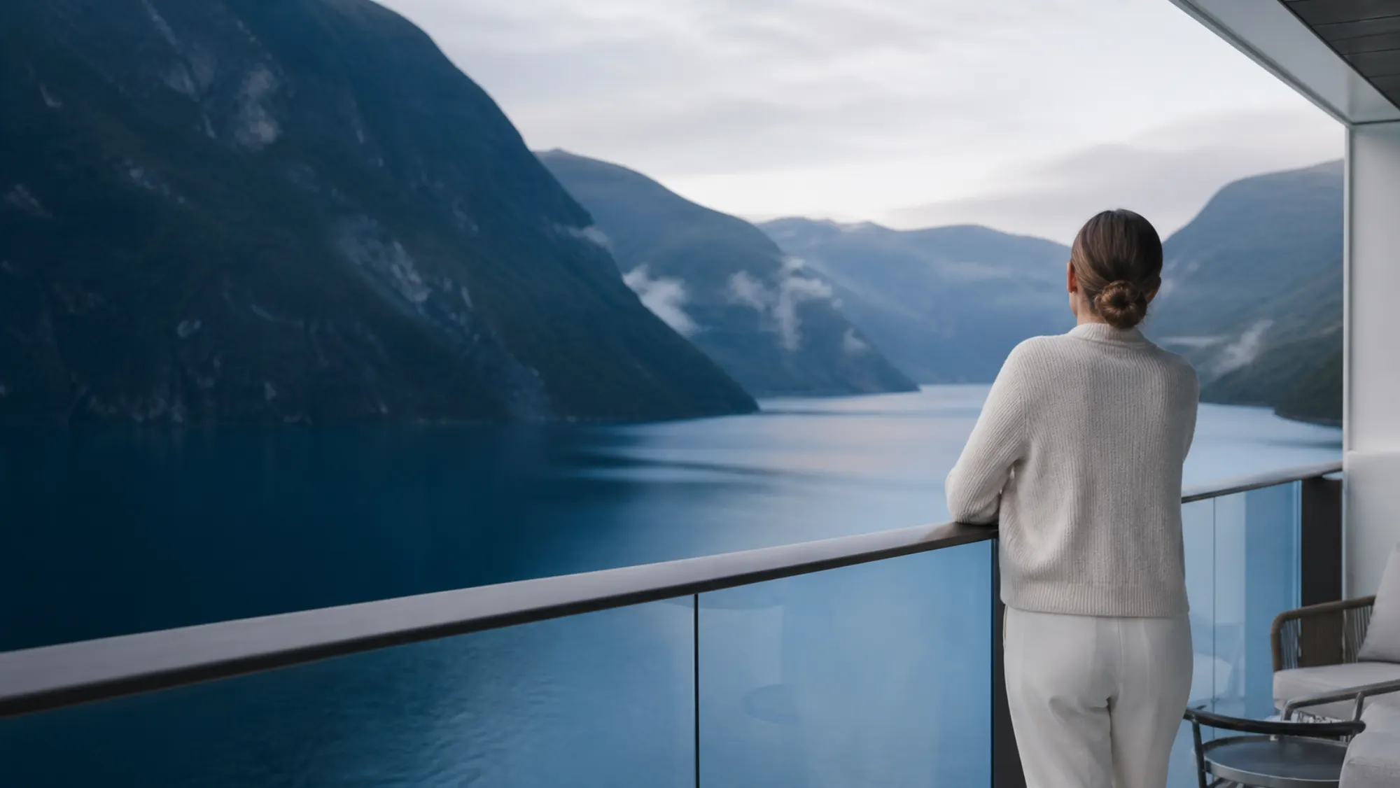 Reisende blickt von einem Kreuzfahrtschiff auf einen norwegischen Fjord