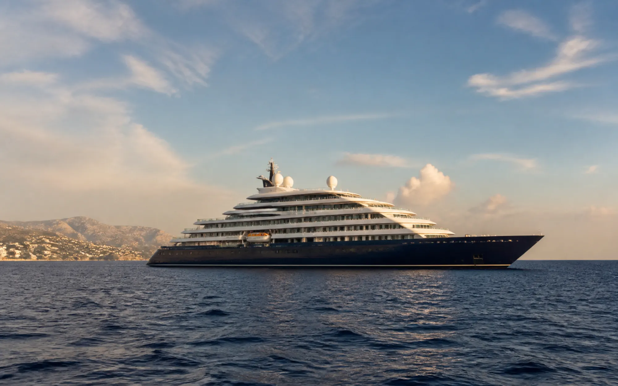 Elegantes Luxusschiff vor einer mediterranen Küste im warmen Abendlicht