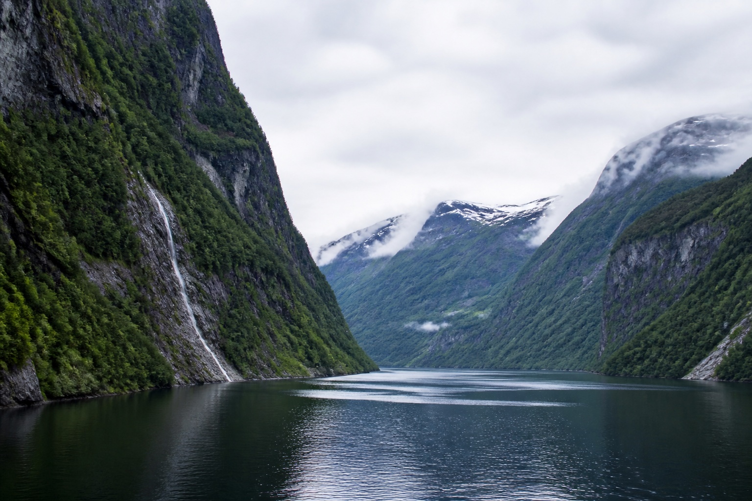 Grüne Fjordwände und Wasserfälle über einem norwegischen Fjord