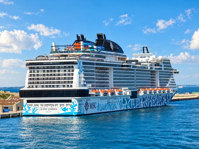 Die MSC Euribia in Kopenhagen, schräg von achtern gesehen. Licht, Himmel, Wasser und Farben wurden mit KI bearbeitet.